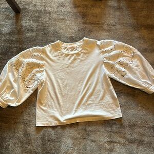 Feminine scoop neck cotton top with lace sleeves in white.